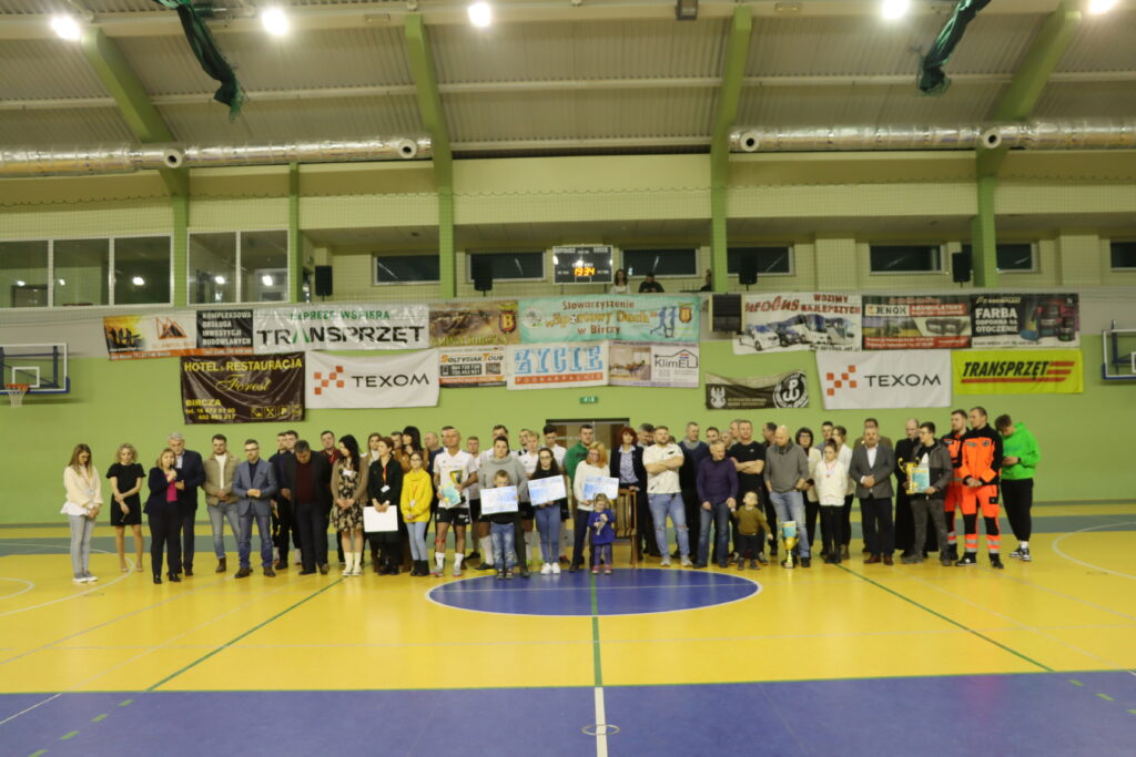 Zdjęcie grupowe na hali sportowej organizatorów i drużyn biorących udział w turnieju