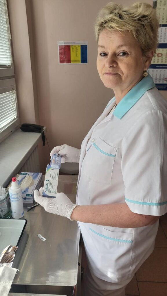 pielęgniarka trzyma w rękach opakowanie ze szczepionką
