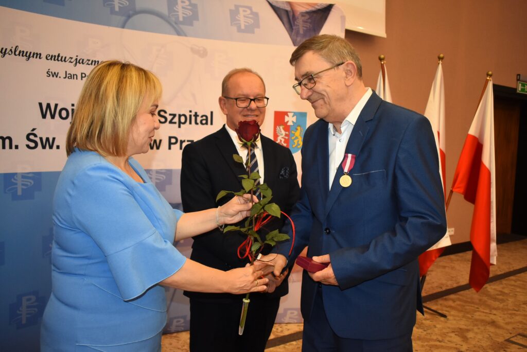dyrektor szpitala wręcza różę lekarzowi, obok wicewojewoda