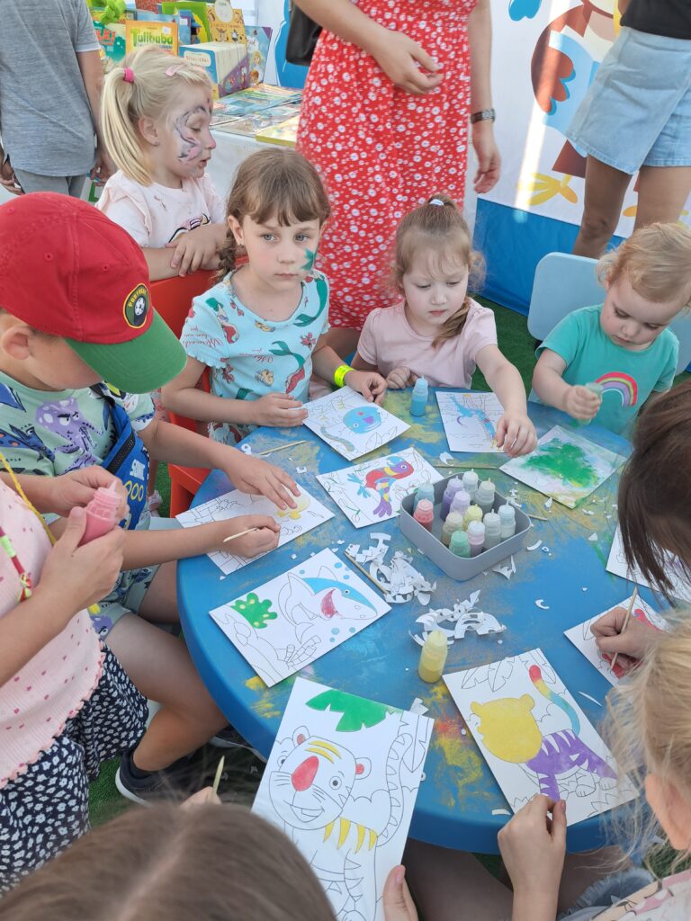 Dzieci przy stoliku malują obrazki
