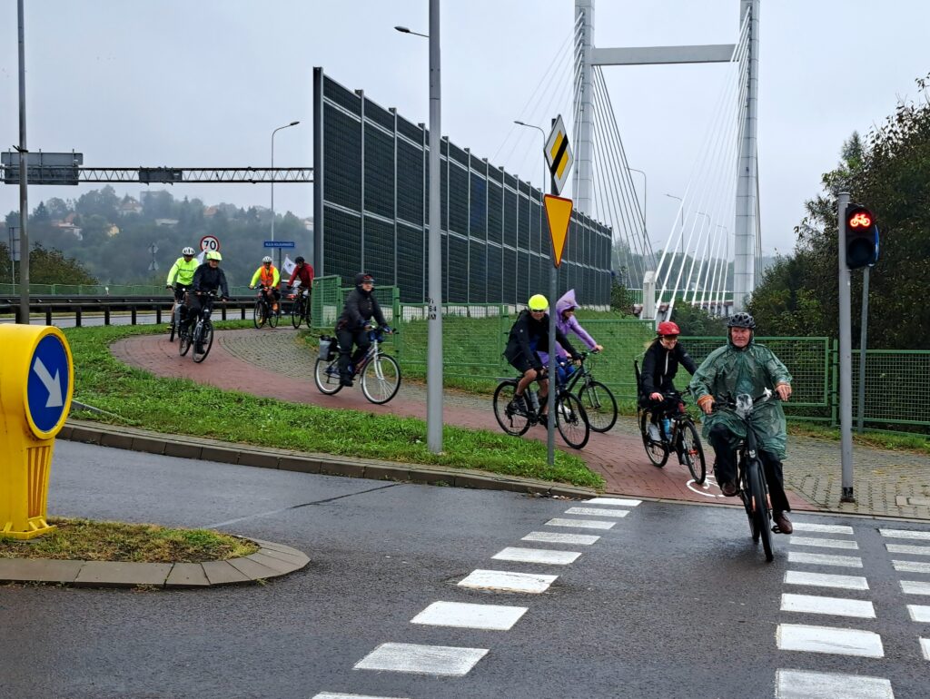 rowerzyści przejeżdżają po ścieżce rowerowej przez skrzyżowanie