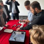 Jeden mężczyzna pokazuje nowoczesny stent żylny, grupa osób przygląda się