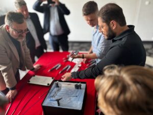 Jeden mężczyzna pokazuje nowoczesny stent żylny, grupa osób przygląda się