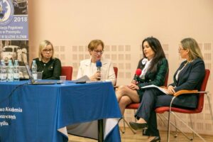 przy stole przykrytym niebieskim obrusem siedzą 4 kobiety uczestniczące w panelu dyskusyjnym