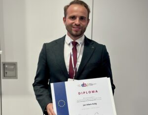 lekarz w garniturze prezentuje dyplom