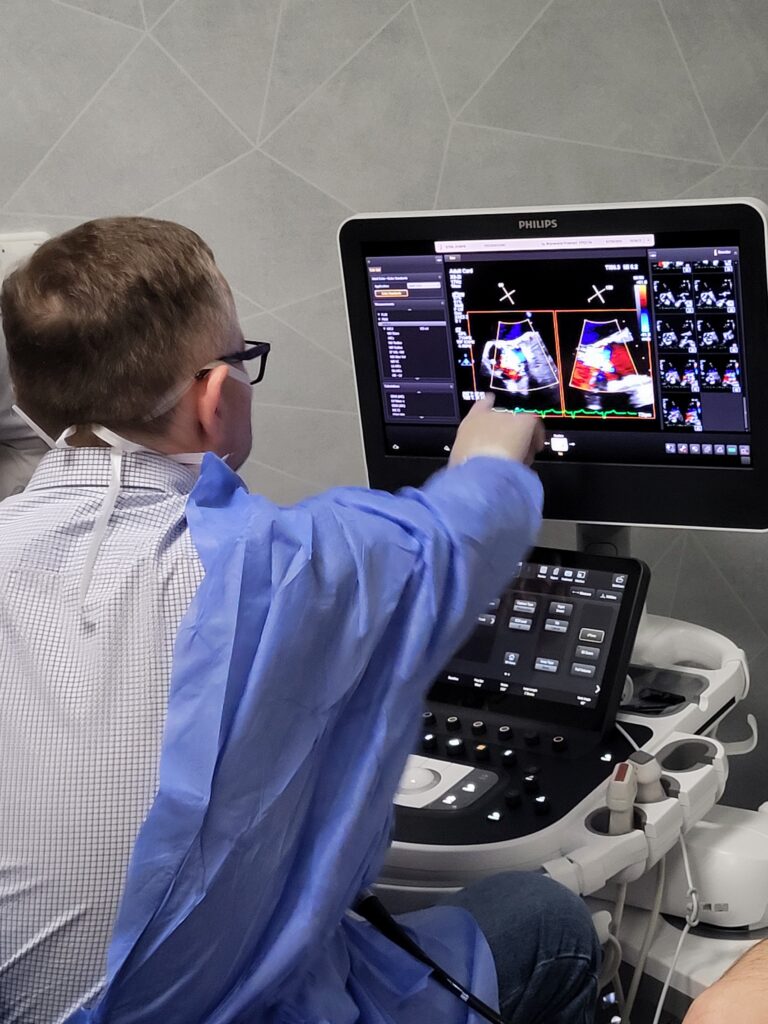 lekarz wskazuje palcem na obraz na ekranie USG