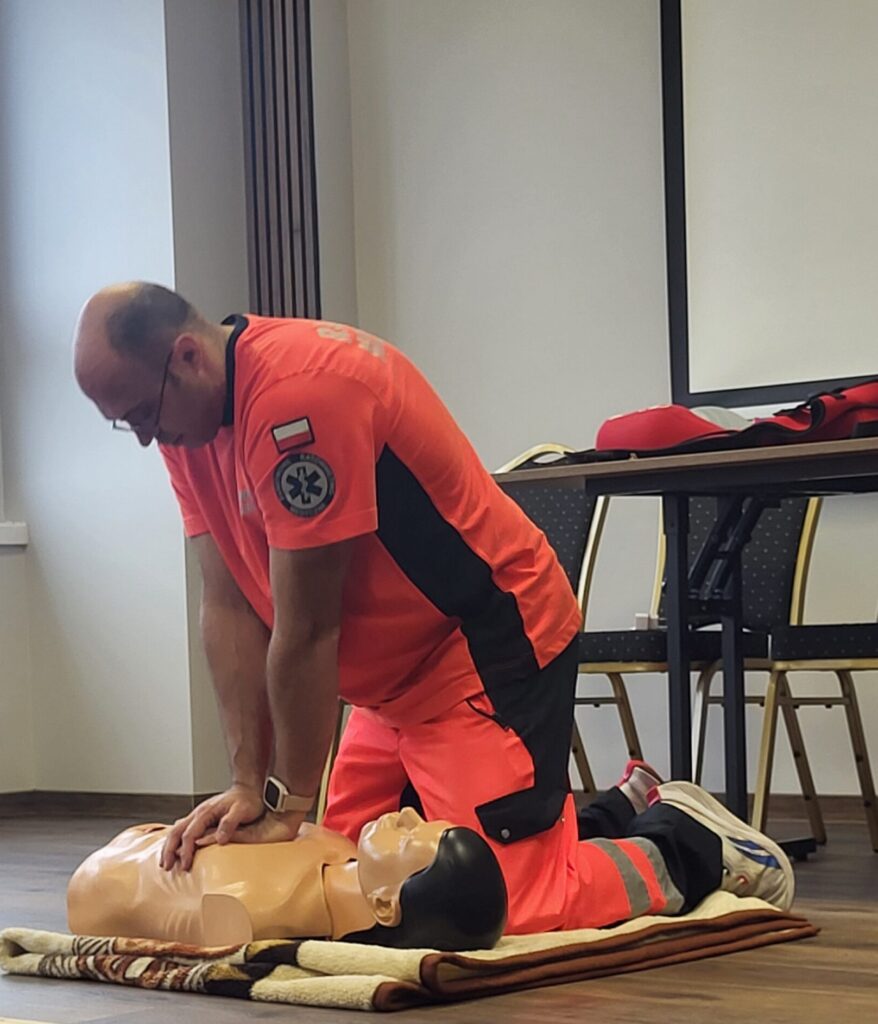 ratownik demonstruje resuscytację na fantomie