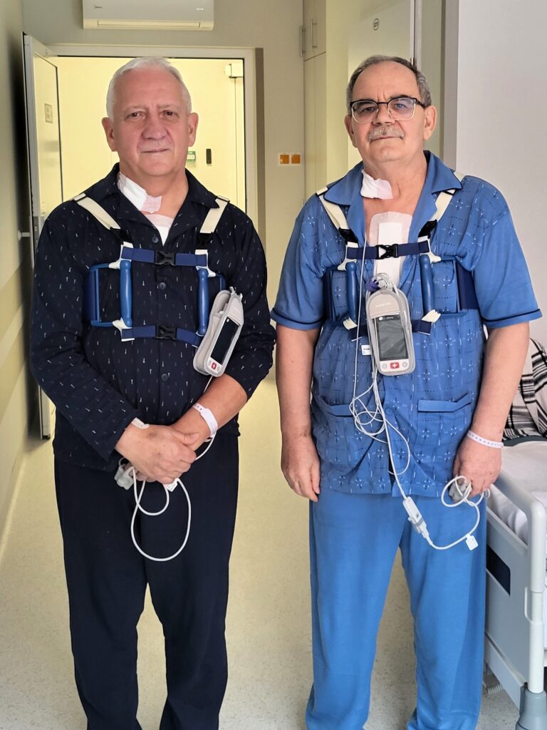 dwóch pacjentów stoi w sali szpitalnej