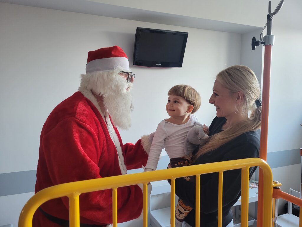 Mikołaj i kobieta trzymająca dziecko na rękach