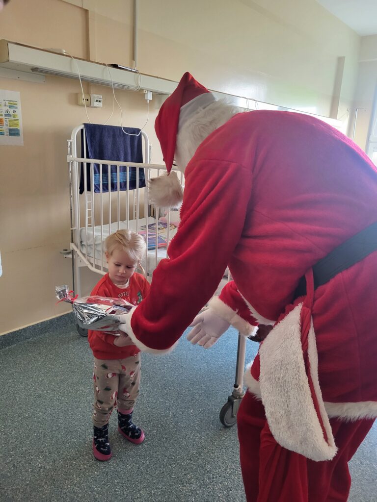 św. Mikołaj wręcza prezent małej dziewczynce