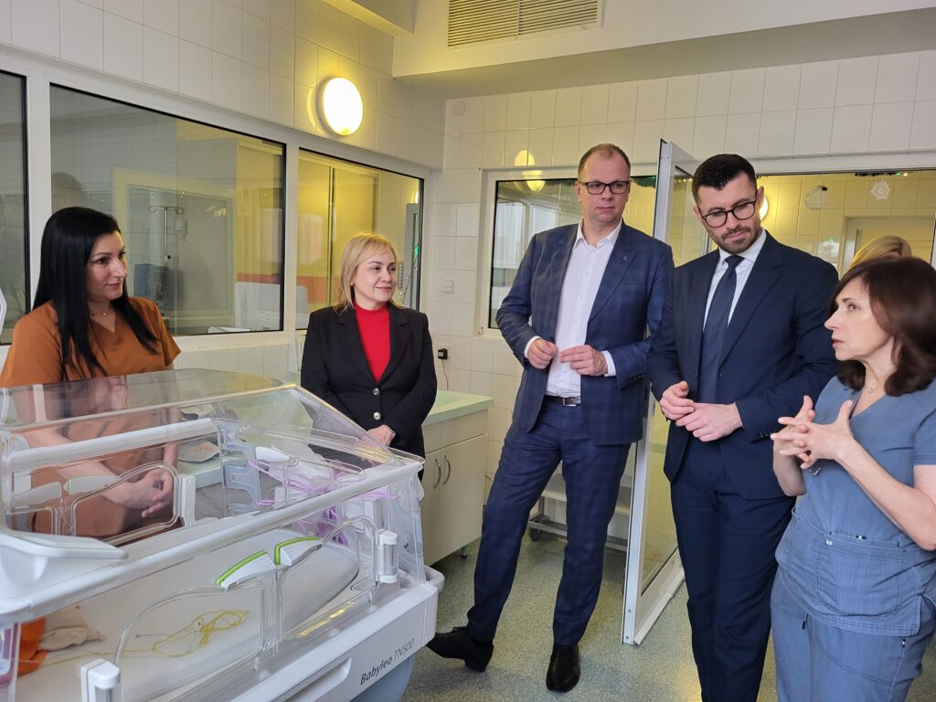 przy inkubatorze stoją prezydent i zastępca, dyrektorka, pielęgniarka i lekarka