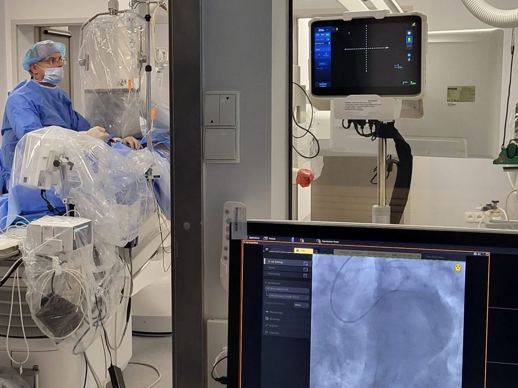 pracownia hemodynamiki, po lewej stronie lekarz wykonujący zabieg, po prawej monitor