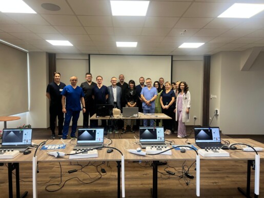 uczestnicy szkolenia na zdjęciu grupowym na sali szkoleniowej, przed nimi na stołach symulatory