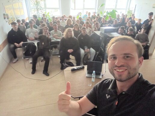 lekarz pokazuje kciuka w górę, za nim siedzi młodzież